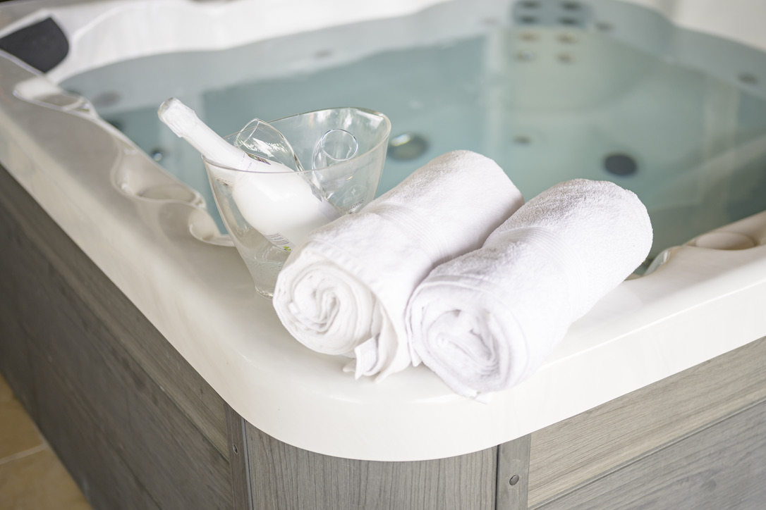 Hot tub with rolled towels and glasses at Bayside Hill