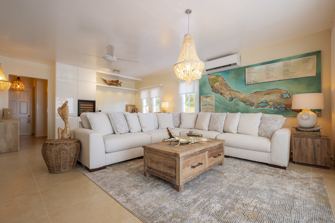 Living room with pale seating and natural wood at Castaway Beach