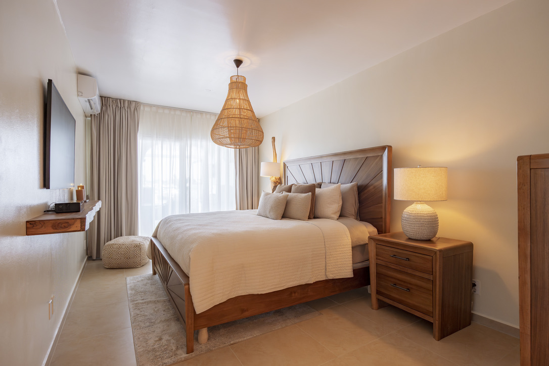 First bedroom with a carved wood bed at Castaway Beach