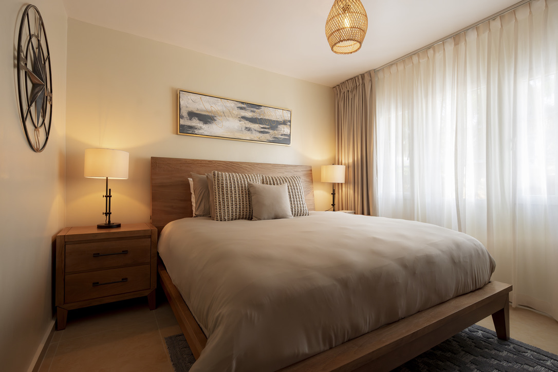 Third bedroom with a natural wood bed at Castaway Beach
