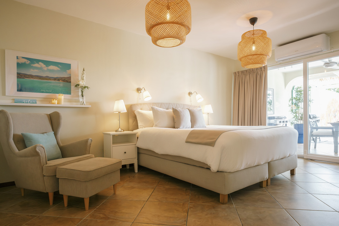 Spacious king bedroom opening onto the terrace at Happy Hideaway