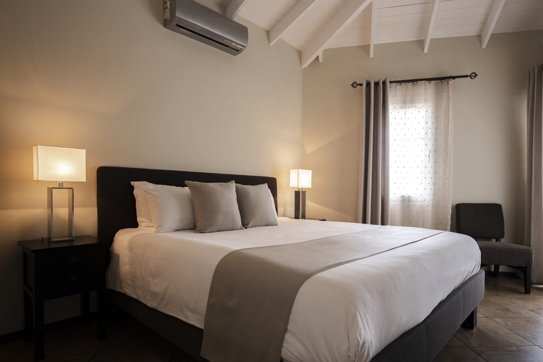 Wide bedroom view beneath the white ceiling at Palm Breeze