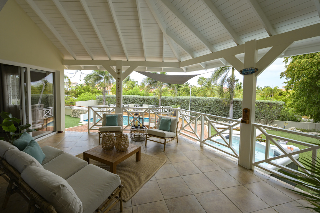 Covered veranda overlooking the pool at Palm Breeze