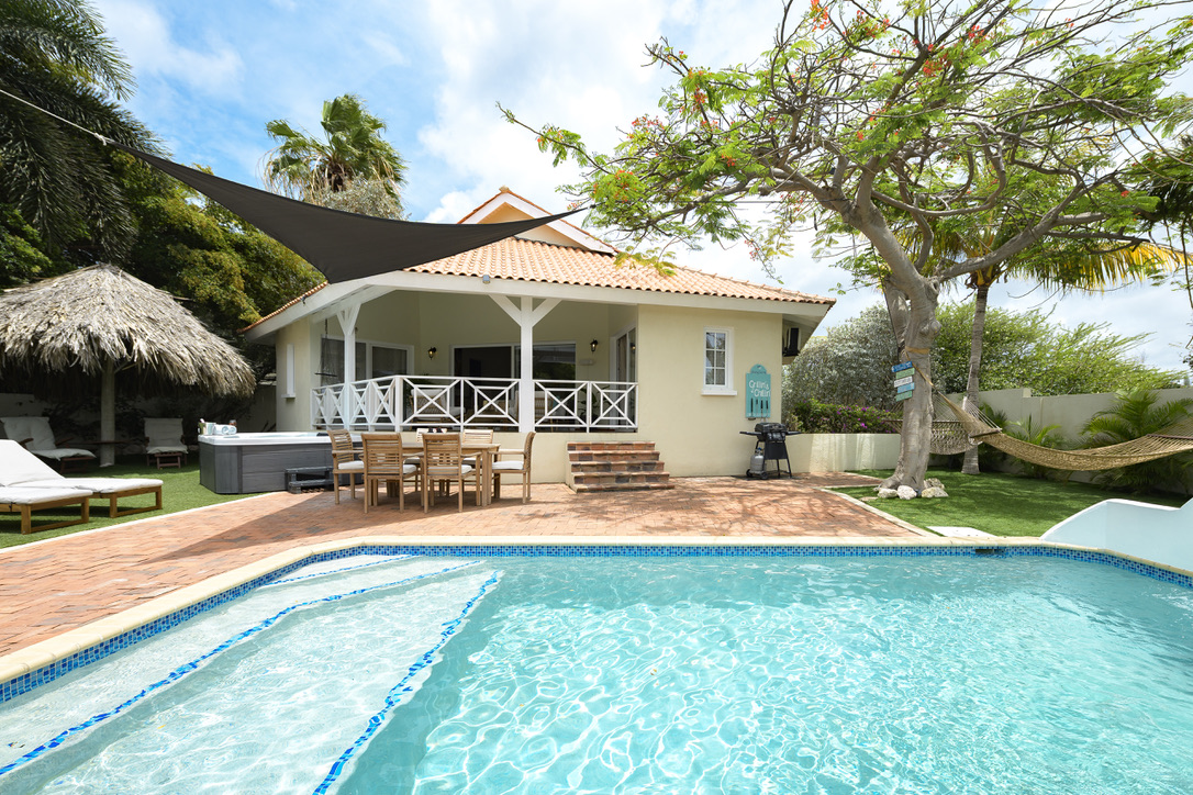Pool and house beneath the shade sail at Palm Breeze